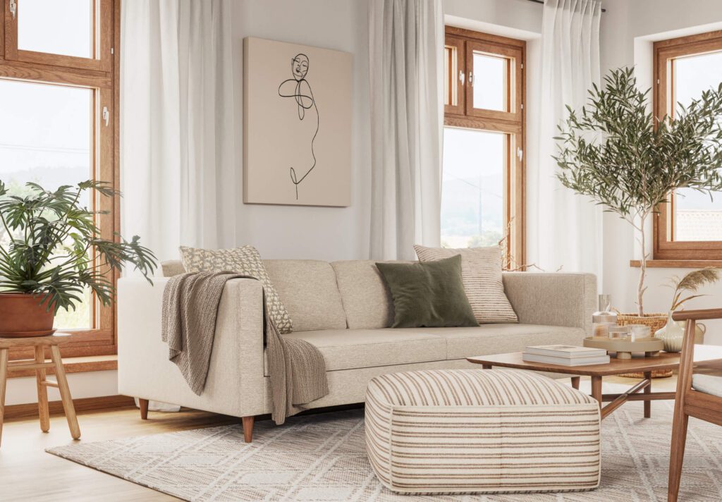 living room with white sofa with green p pillow and throw blanket, white and tan striped ottoman