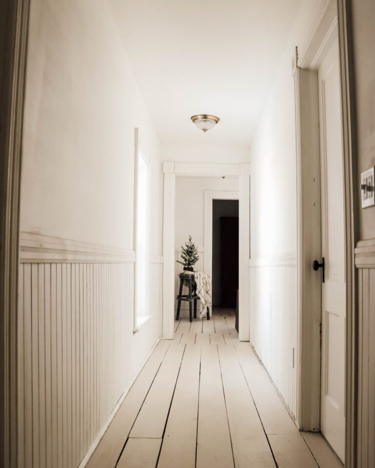 white hallway with painted white wood plank floors