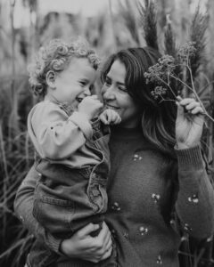black and white photo of mother and toddler holding flowers