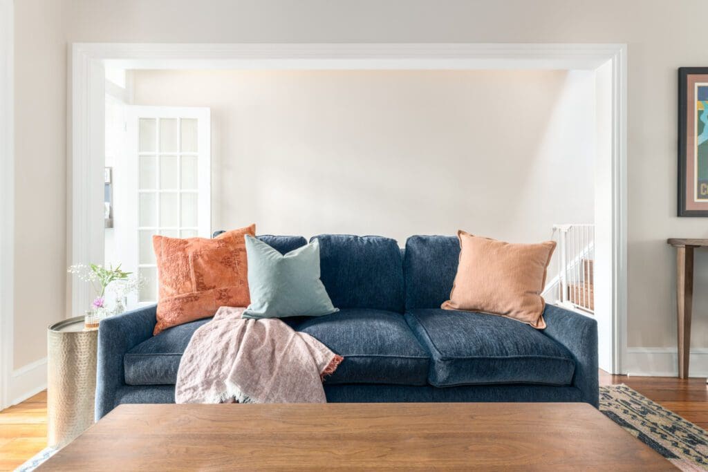 Denim blue couch with pink and blue pillows designed by sustainable interior designer Johanna Adamiak