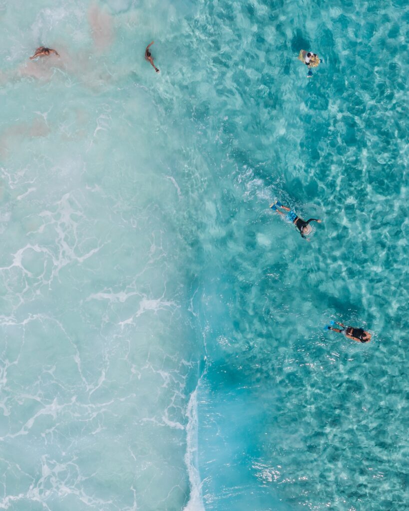 blue ocean with people floating