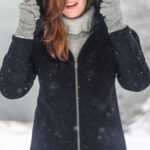 woman in black winter coat in the snow