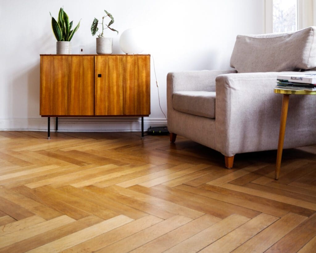 eco friendly flooring in herringbone pattern with arm chair and credenza
