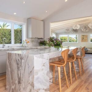 kitchen with white and grey marble island and modern natural wood chairs