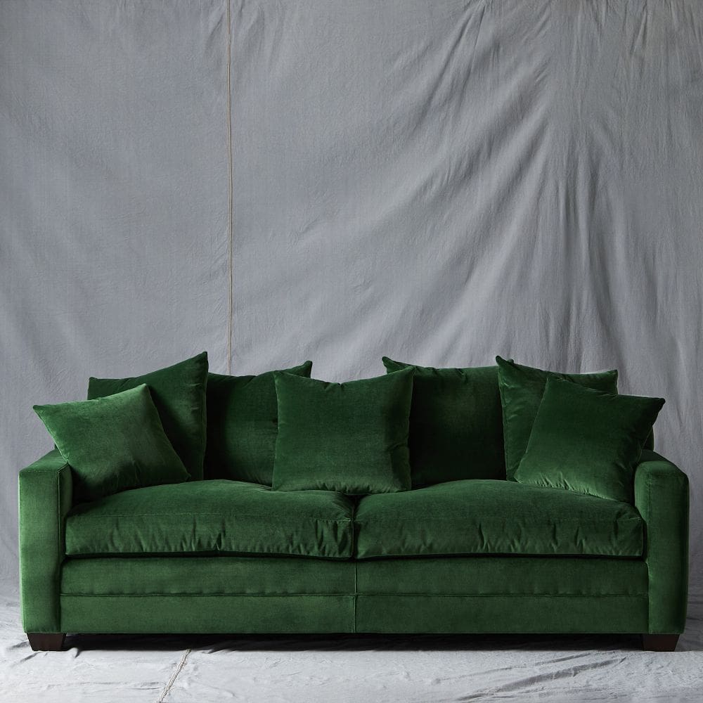 velvet green sofa with grey backdrop